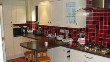 new kitchen with breakfast bar and red wall tiles
